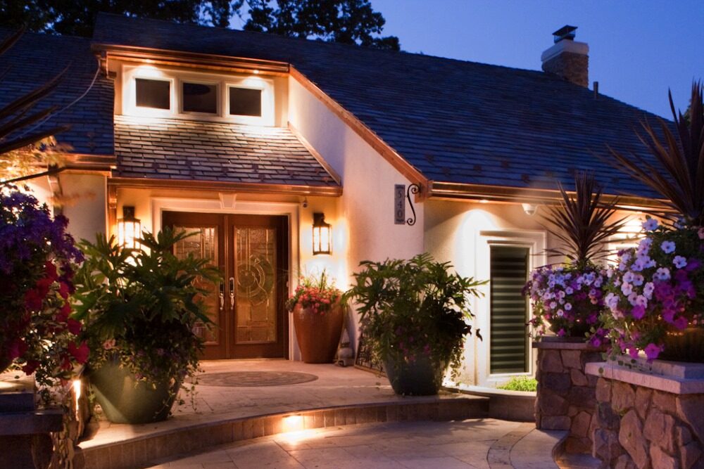 low voltage landscape lighting illuminating walkway and front of home at dusk